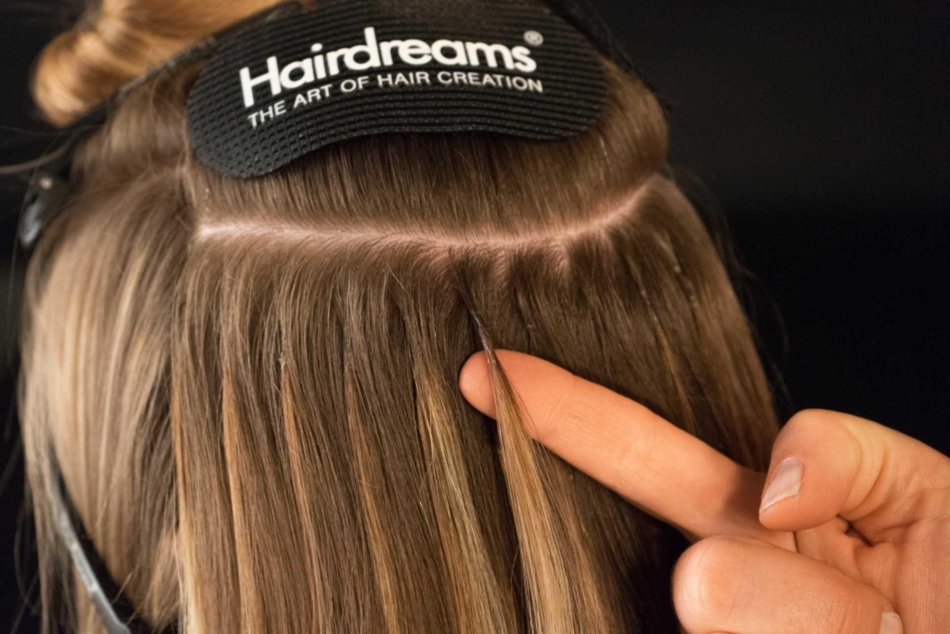 Hair extension being applied to natural hair using Hairdreams techniques.