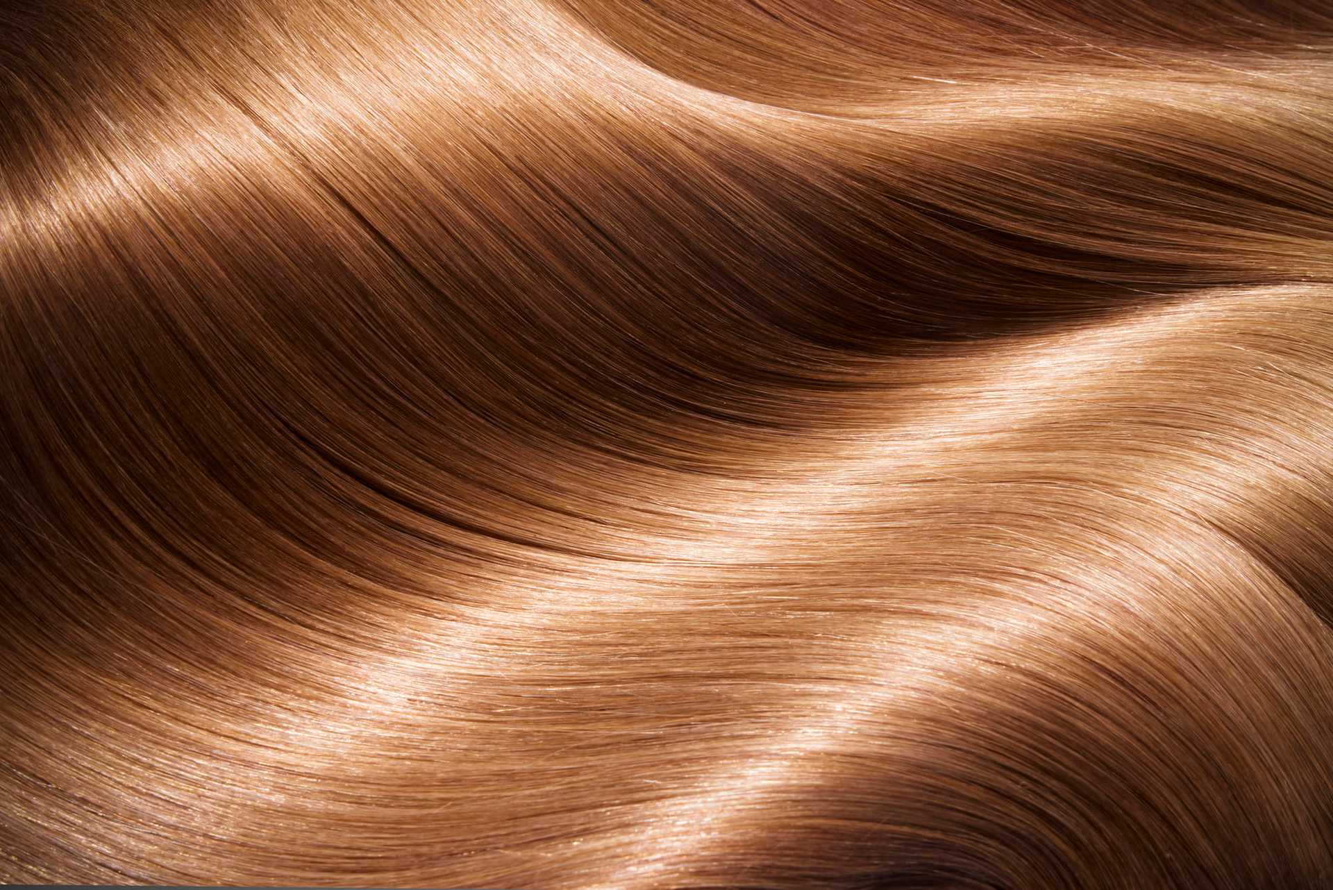 Smooth, shiny strands of healthy brown hair flowing with a glossy texture.
